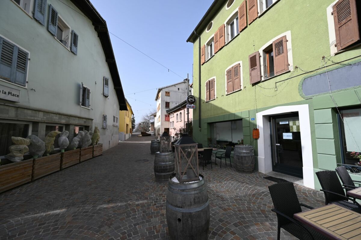 Außenansicht einer engen Gasse mit Café-Terrasse