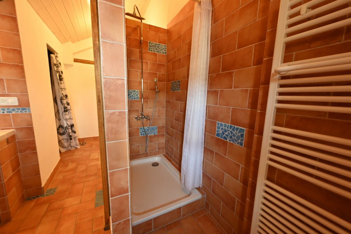 Badezimmer mit Dusche und Fliesen