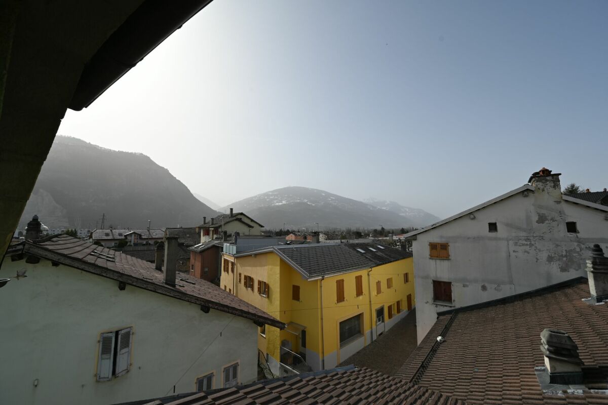 Dachblick auf Wohnhäuser mit Bergkulisse