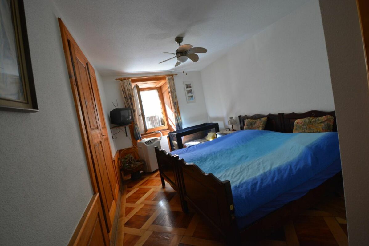 Schlafzimmer mit Holzmöbeln und blauem Bettbezug