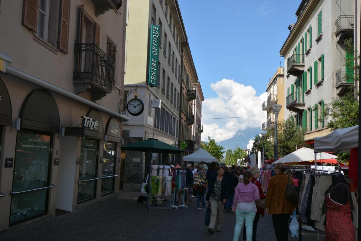Straßenszene mit Ladenfronten und Marktständen