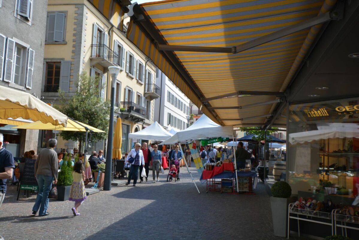 Straßenszene mit Marktständen und Markisen