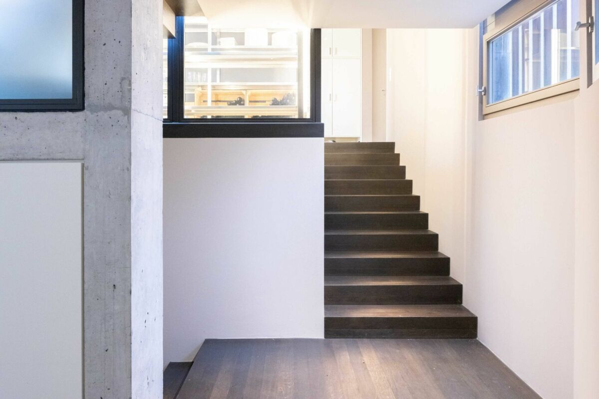 Modernes Treppenhaus mit Sichtbeton und dunklen Stufen