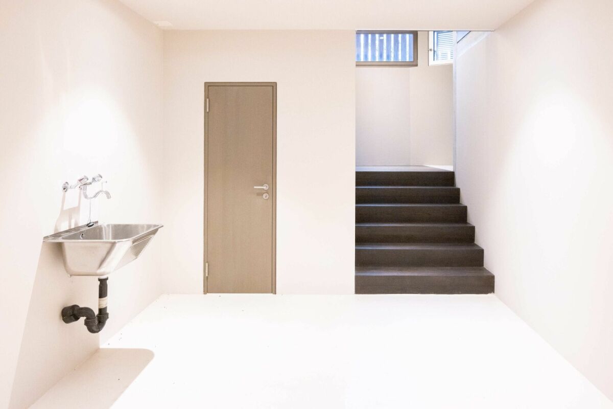 Kleiner heller Raum mit Treppe und Waschbecken