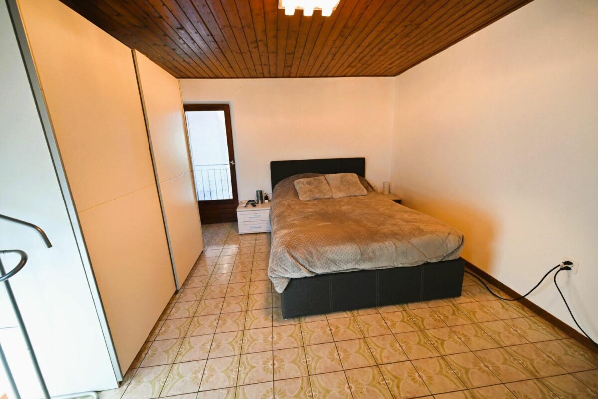 Schlafzimmer mit Holzdecke und Fliesenboden