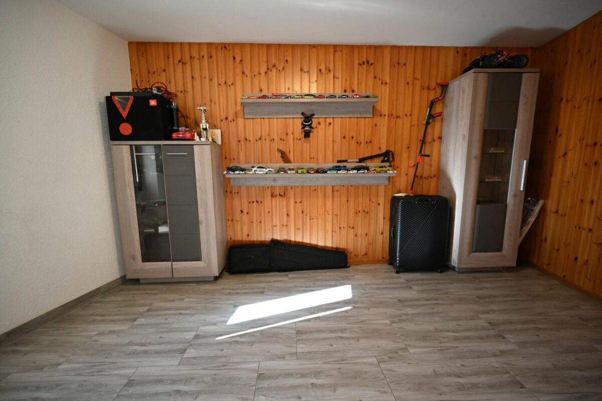 Helles Zimmer mit Holzverkleidung und Stauraummöbeln
