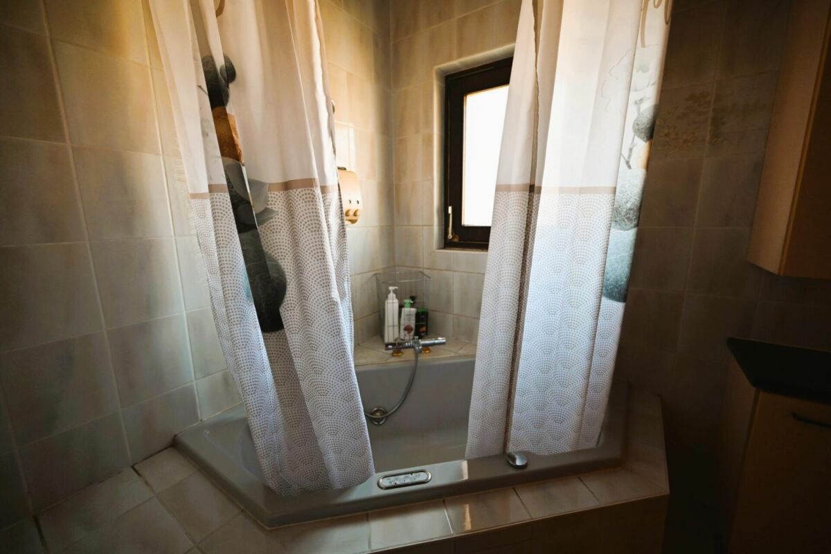Badezimmer mit Badewanne und Vorhang
