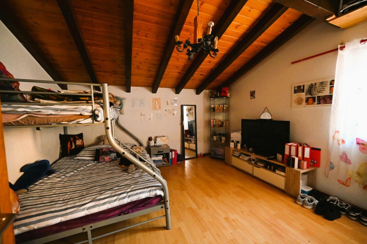Dachzimmer mit Bett und Medienwand