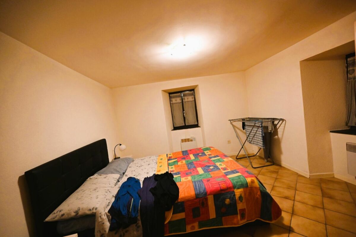 Schlafzimmer mit Bett und kleiner Fensteröffnung