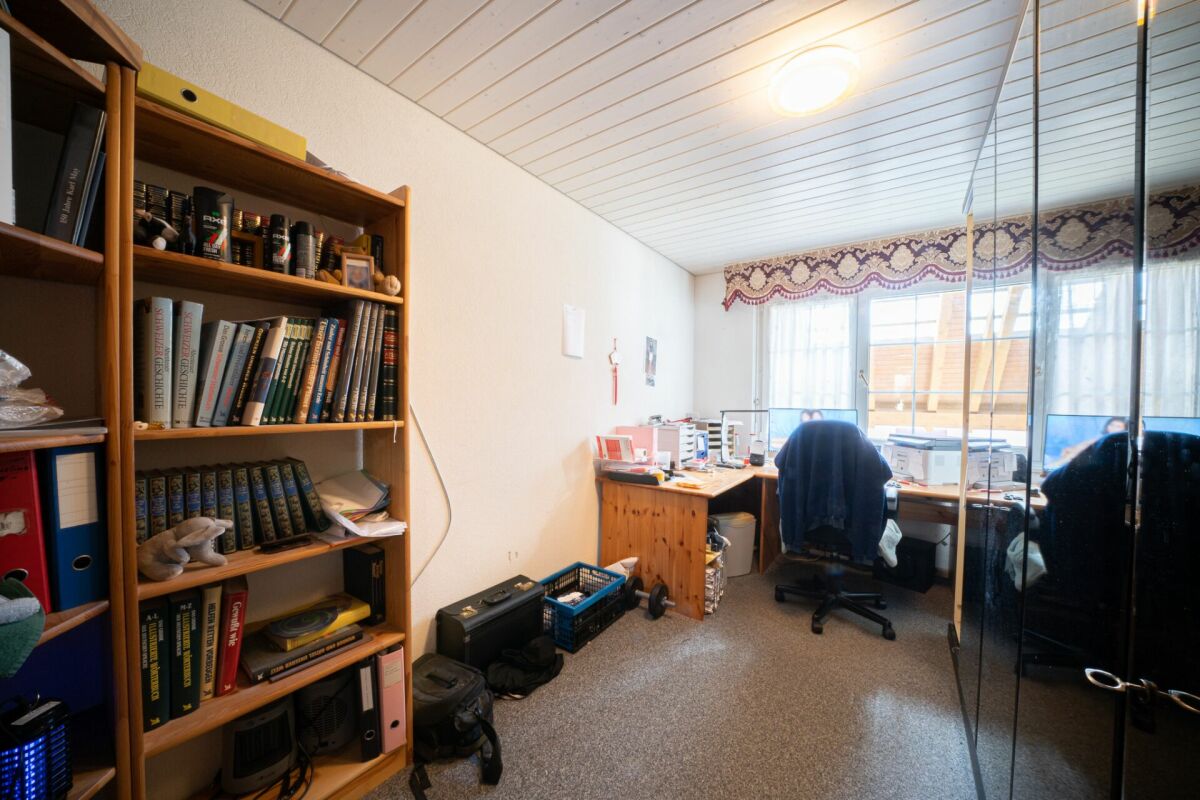 Arbeitszimmer mit Regalwand und Schreibtisch