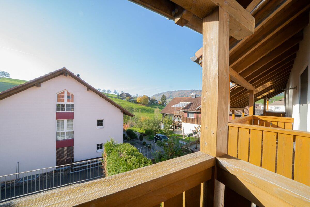 Blick vom Balkon auf die Nachbarhäuser und die Hügellandschaft
