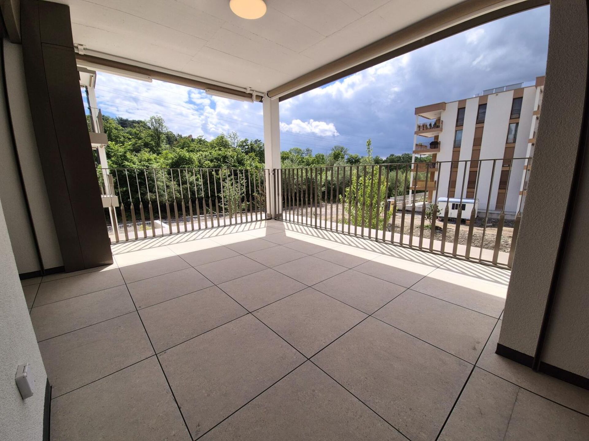 Überdachter Balkon mit Blick ins Grüne