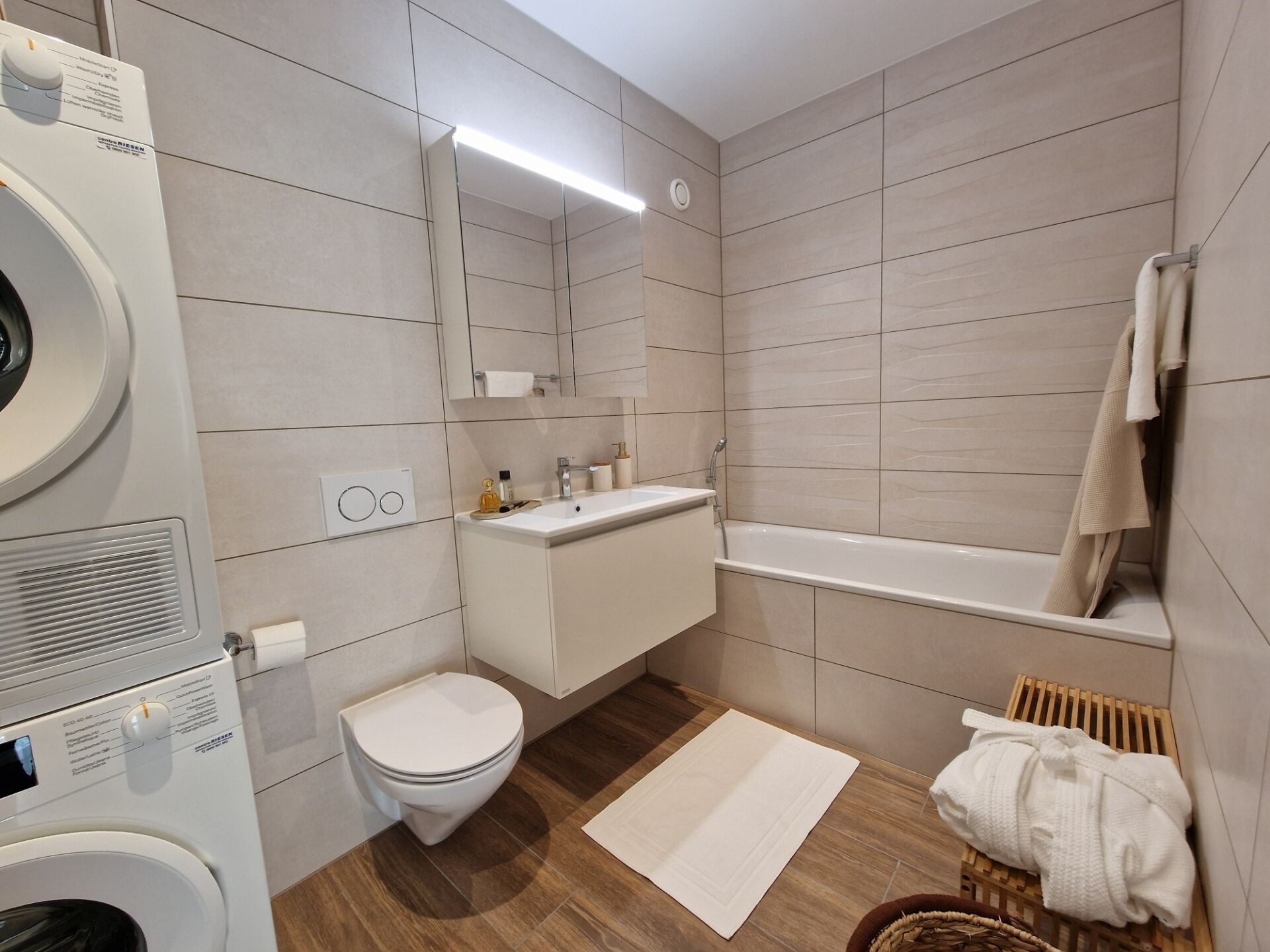 Modernes Badezimmer mit Badewanne und Waschmaschinen-Nische