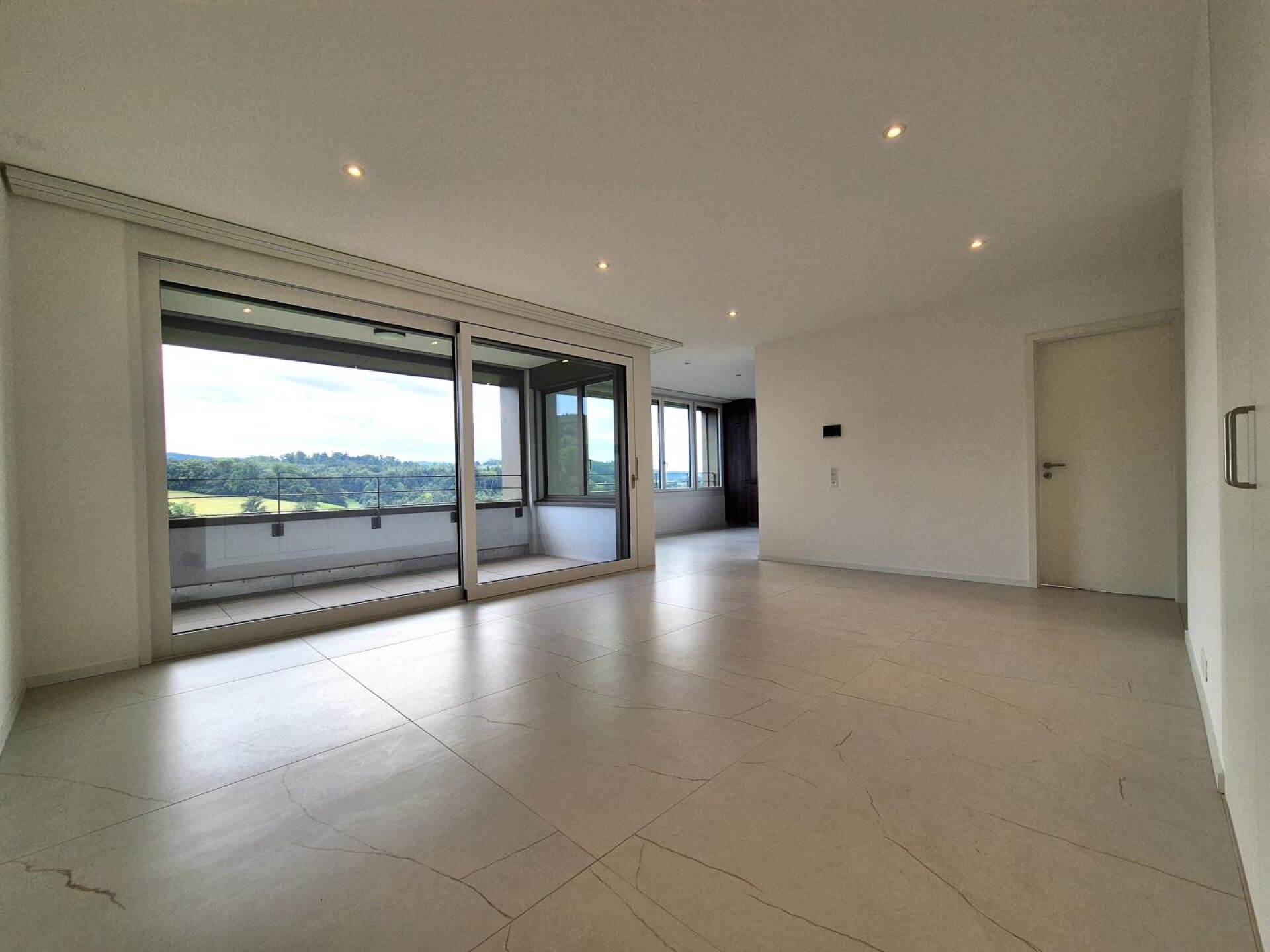 Modernes, helles Wohnzimmer mit Balkonblick