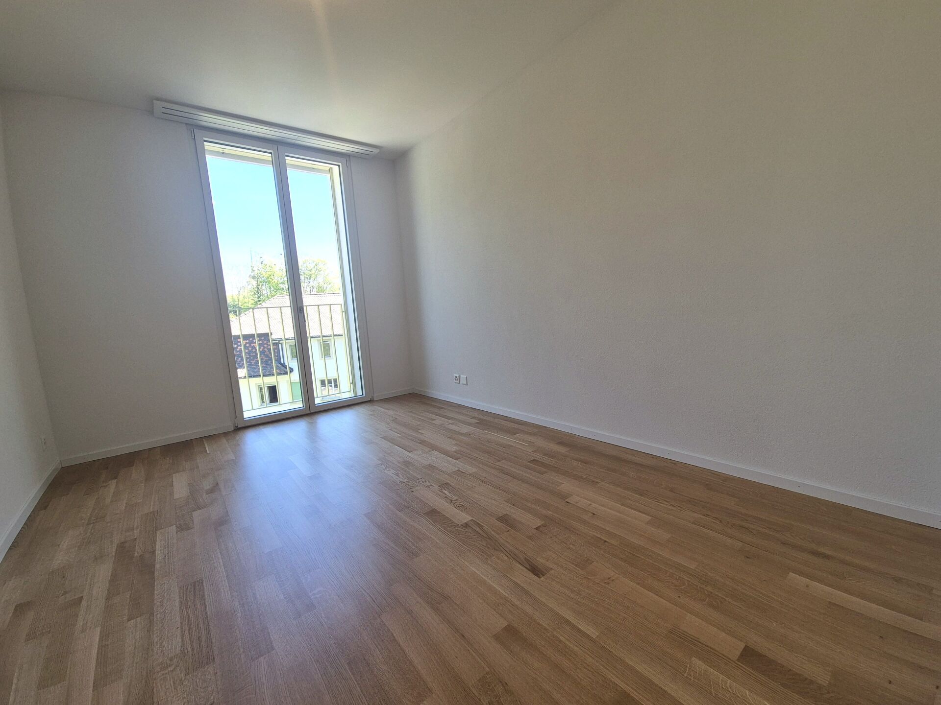 Leerer, heller Raum mit Balkon-/Terrassentür