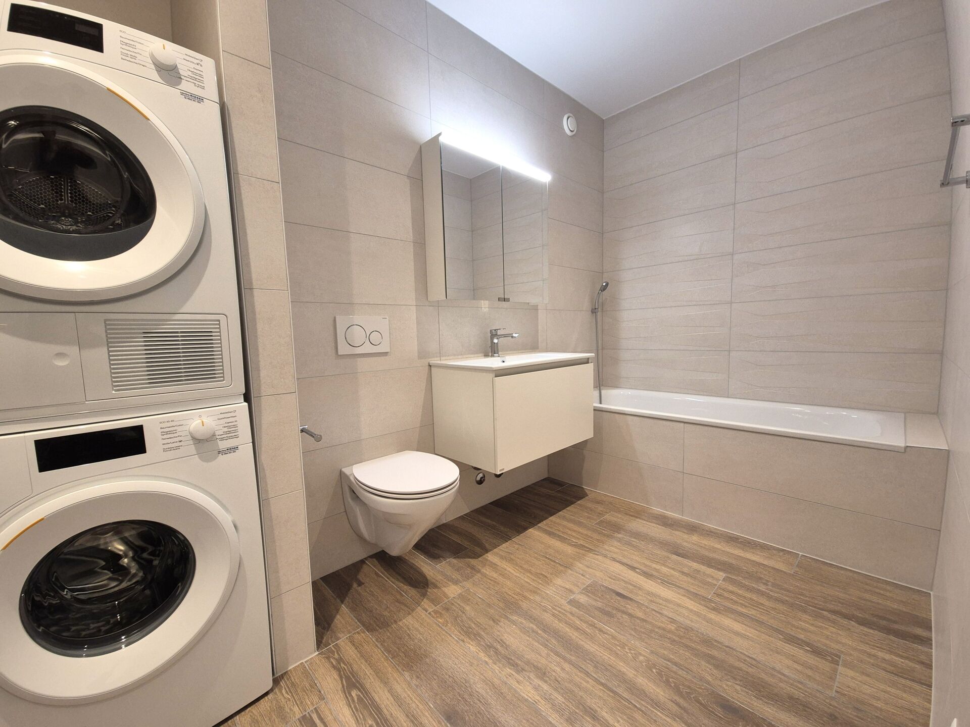 Modernes Badezimmer mit Waschtisch, Wanne und Waschmaschinenbereich