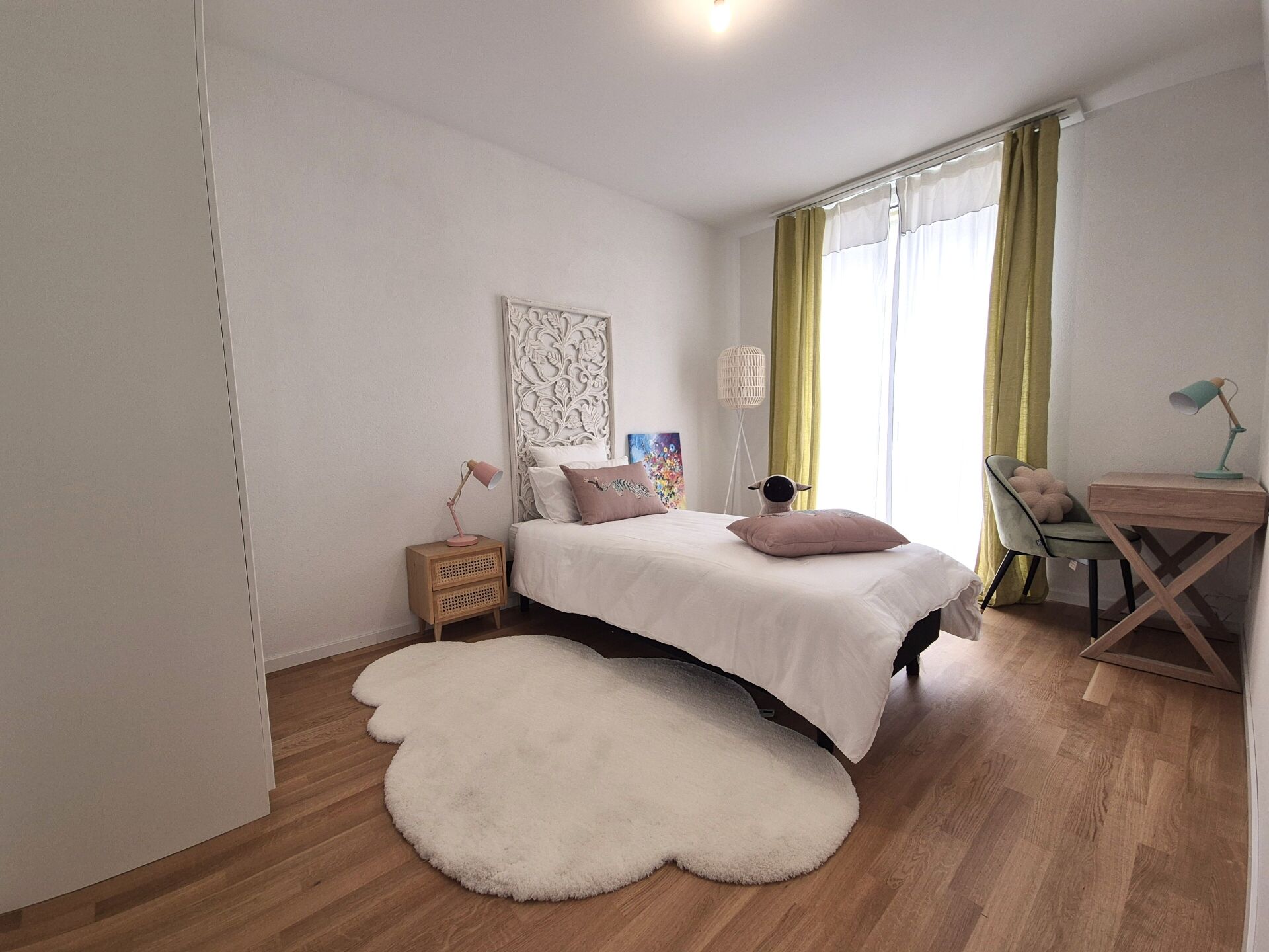 Helles Schlafzimmer mit Einzelbett und Fenster