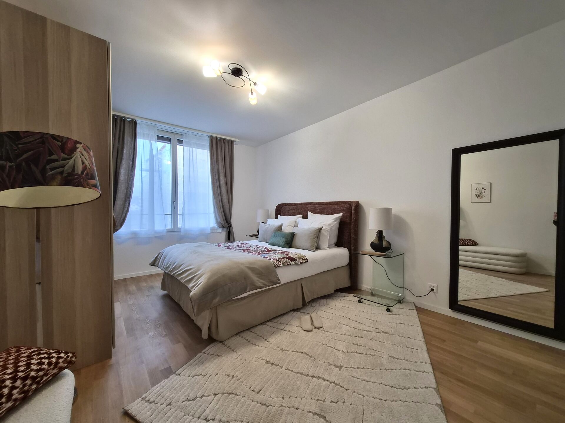 Helles Schlafzimmer mit Spiegel und Fenster