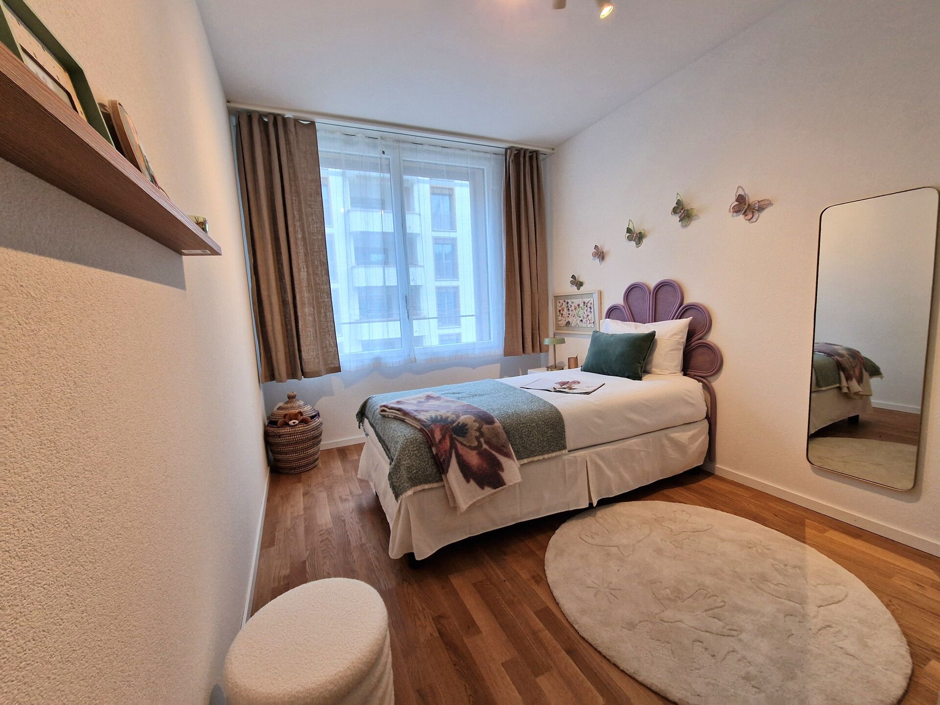 Helles Schlafzimmer mit dekorativem Bett und Balkonfenster