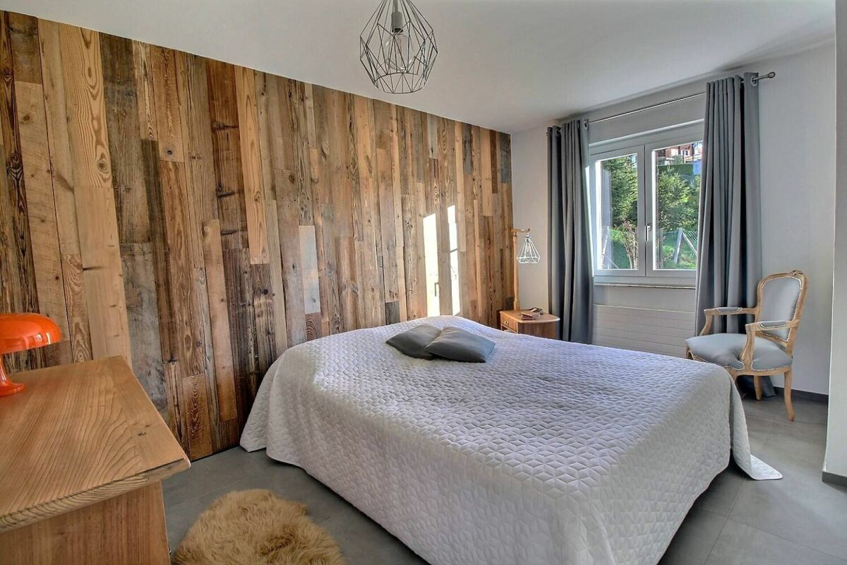Gemütliches Schlafzimmer mit rustikaler Holz-Akzentwand