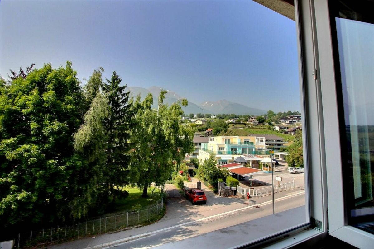 Blick aus einem Fenster auf Wohnumfeld und Berge