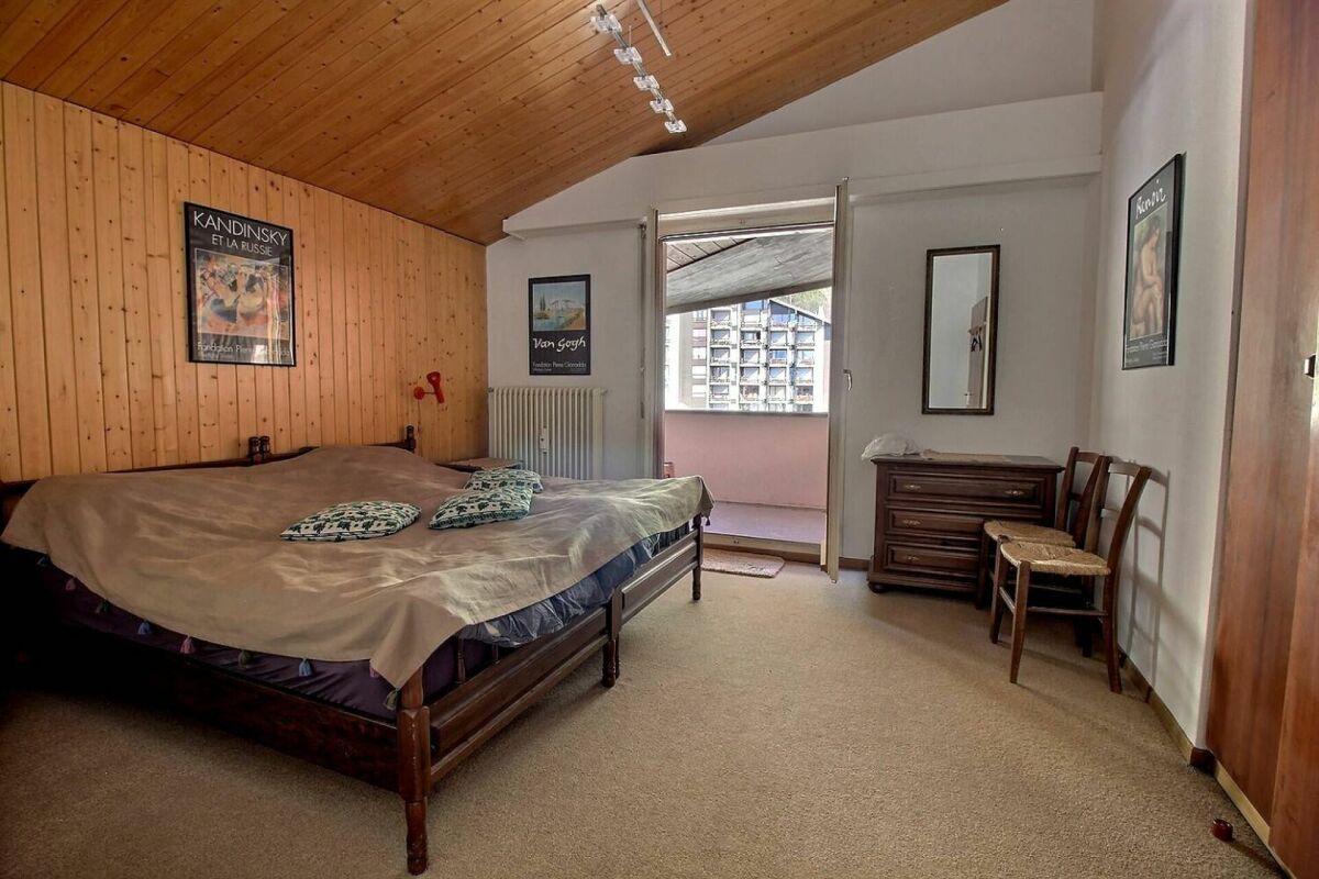 Schlafzimmer mit Holzdecke und Balkon