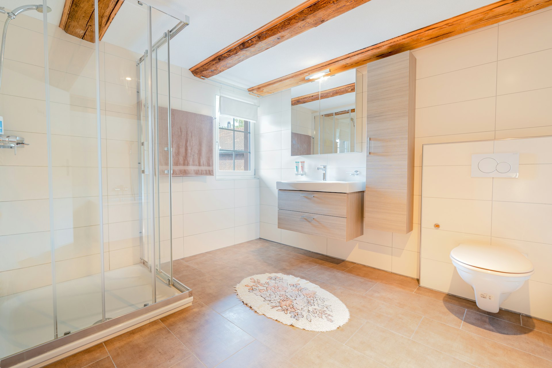 Helles Badezimmer mit Dusche, Waschtisch und WC