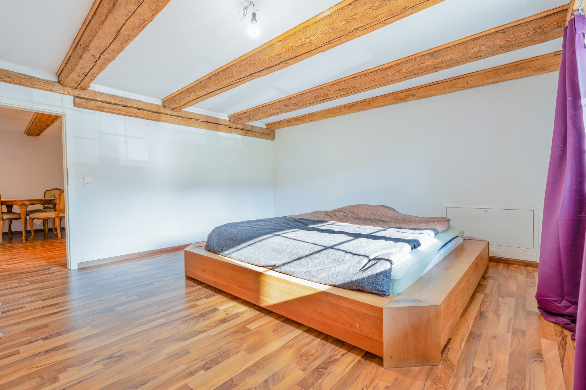 Helles Schlafzimmer mit Holzbalkendecke