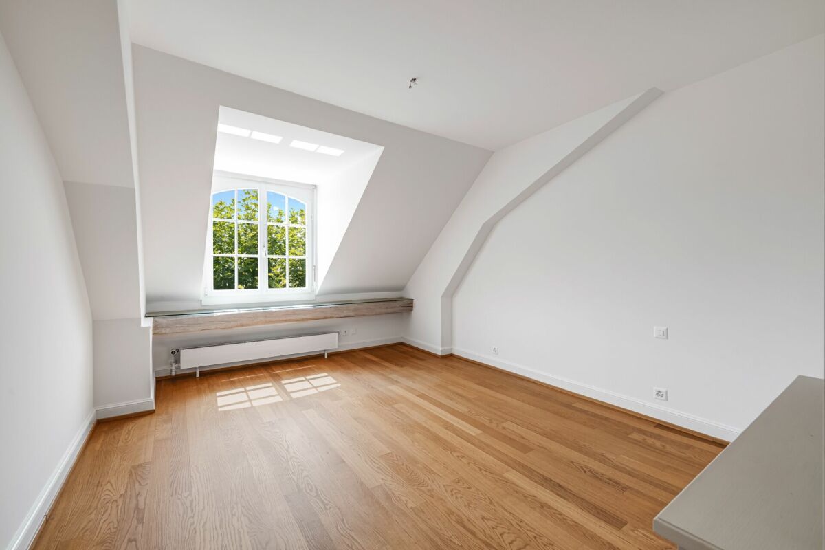 Heller Dachraum mit Holzparkett und Fenster