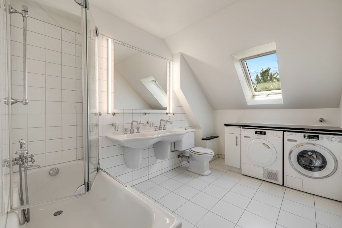 Hell gefliestes Badezimmer mit Dachfenster und Waschtischzeile