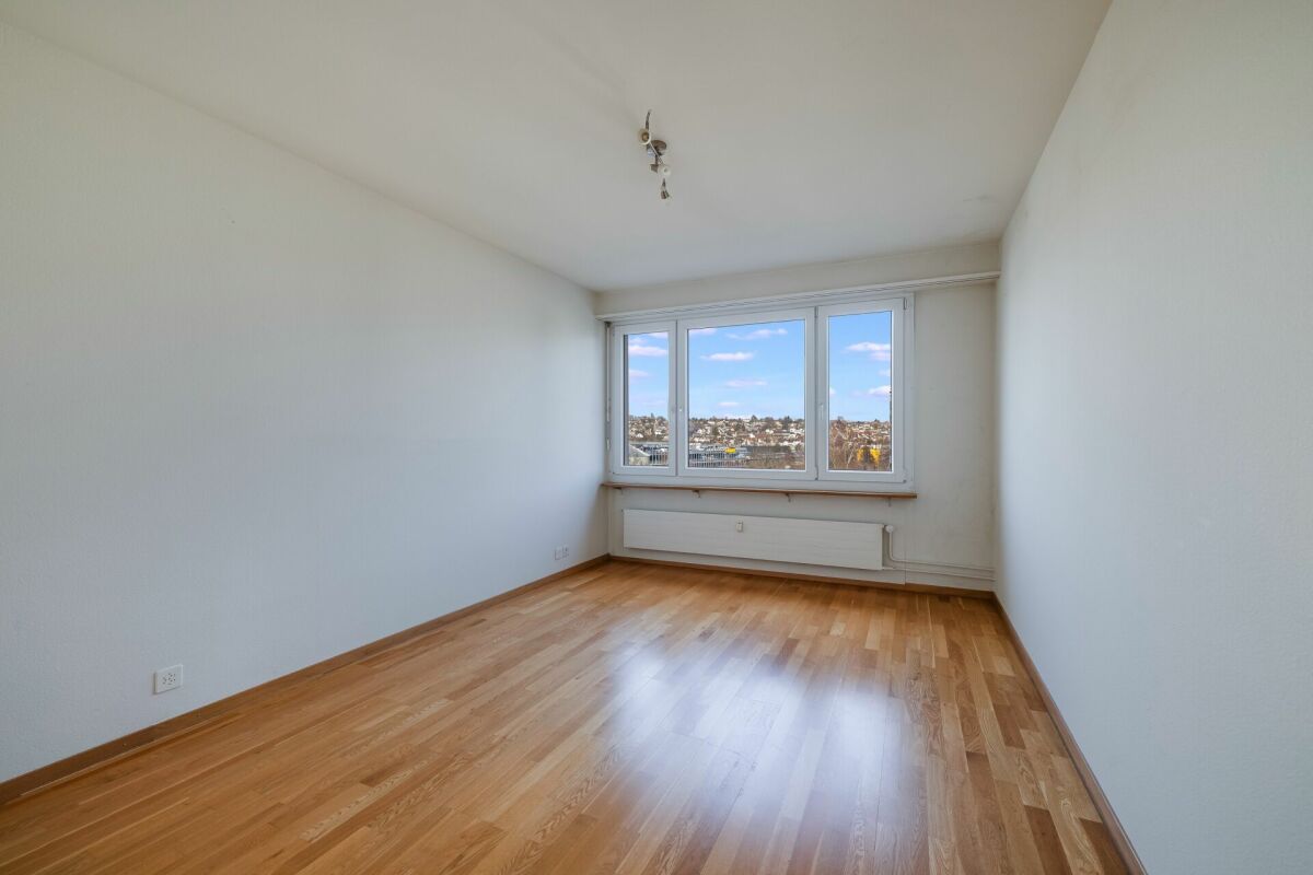 Leerer heller Raum mit Parkett und großem Fenster