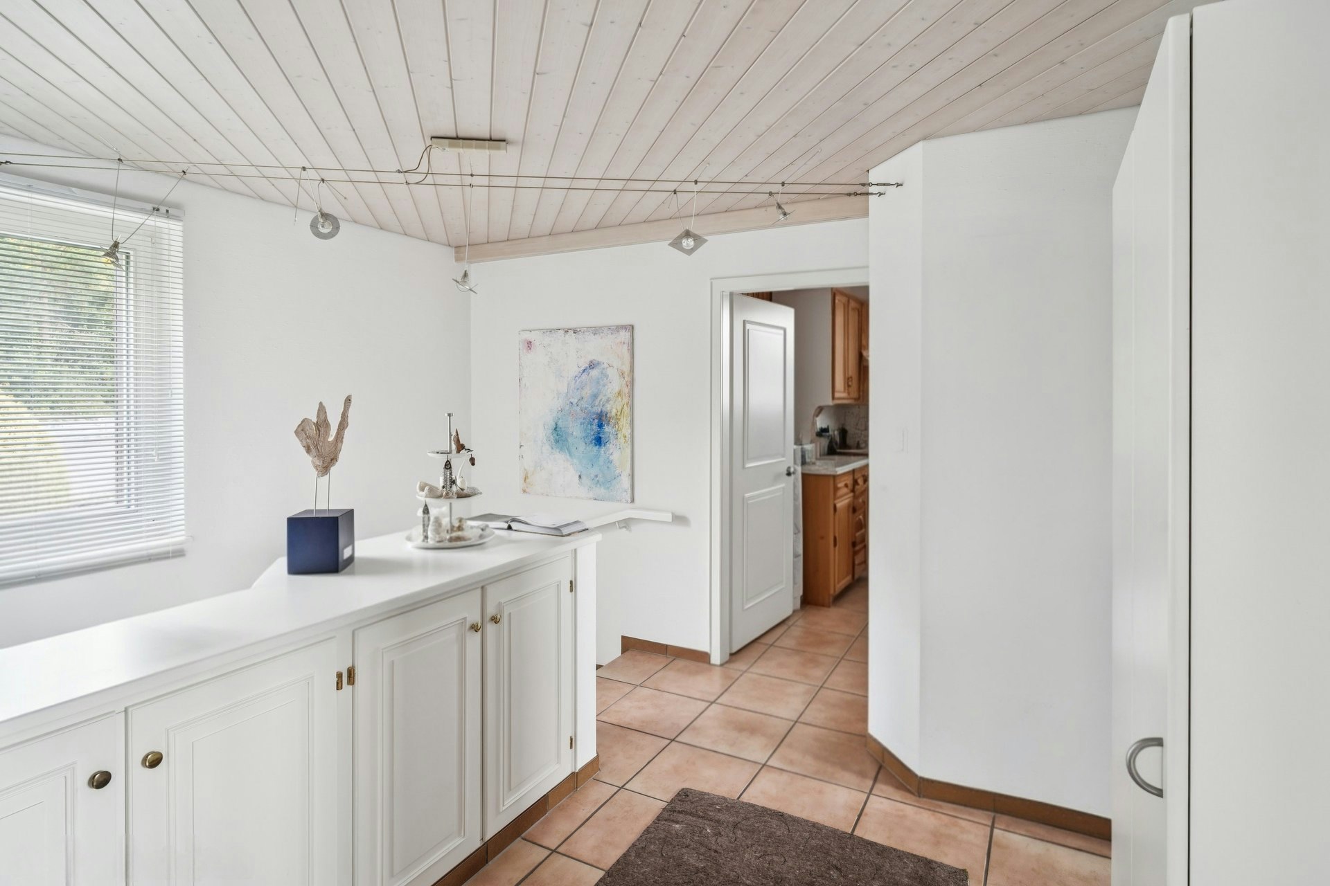 Heller Flur mit Terrakottafliesen und weißem Einbauschrank