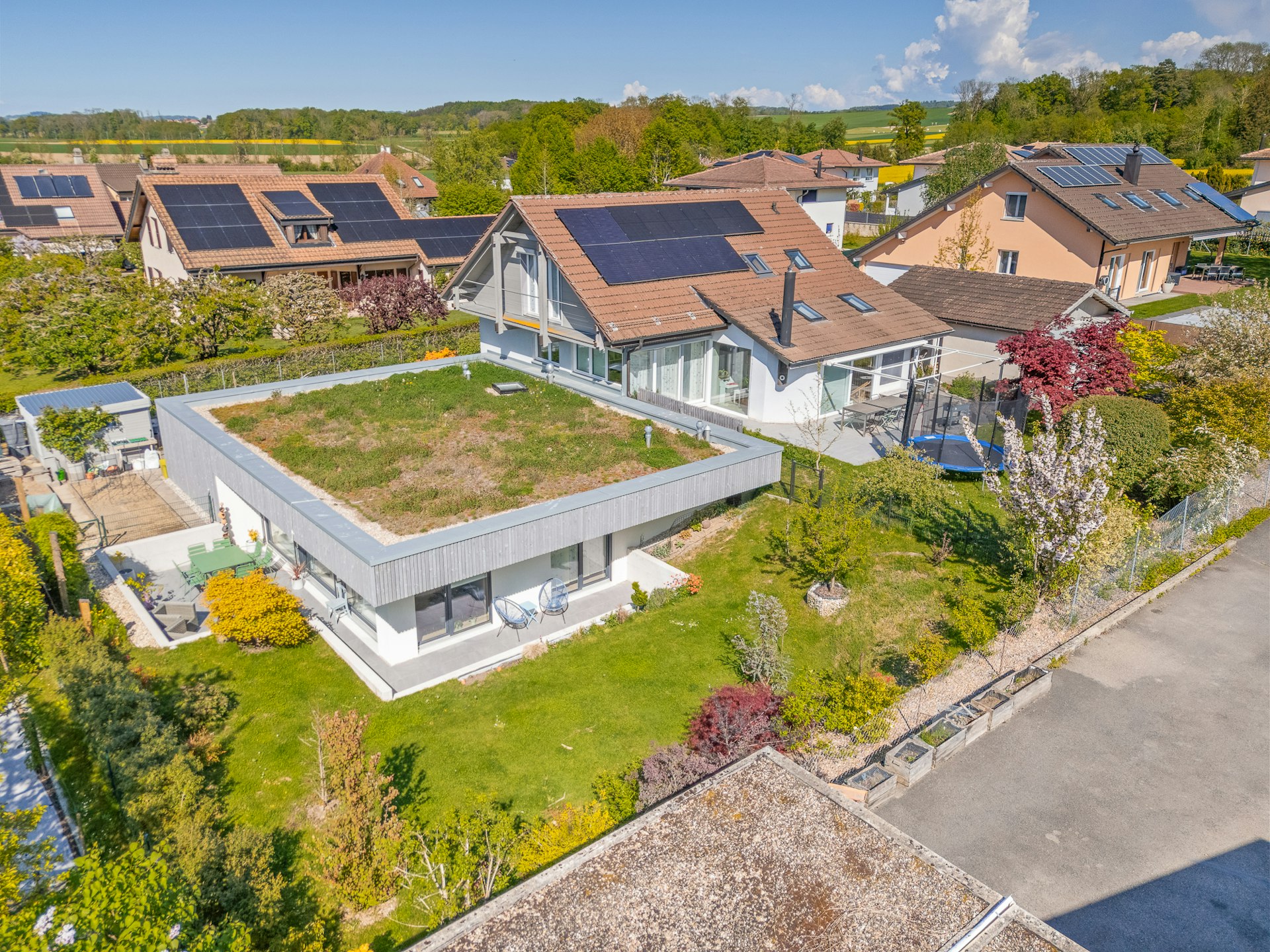 Luftaufnahme eines Wohnhauses mit Garten und Solardächern