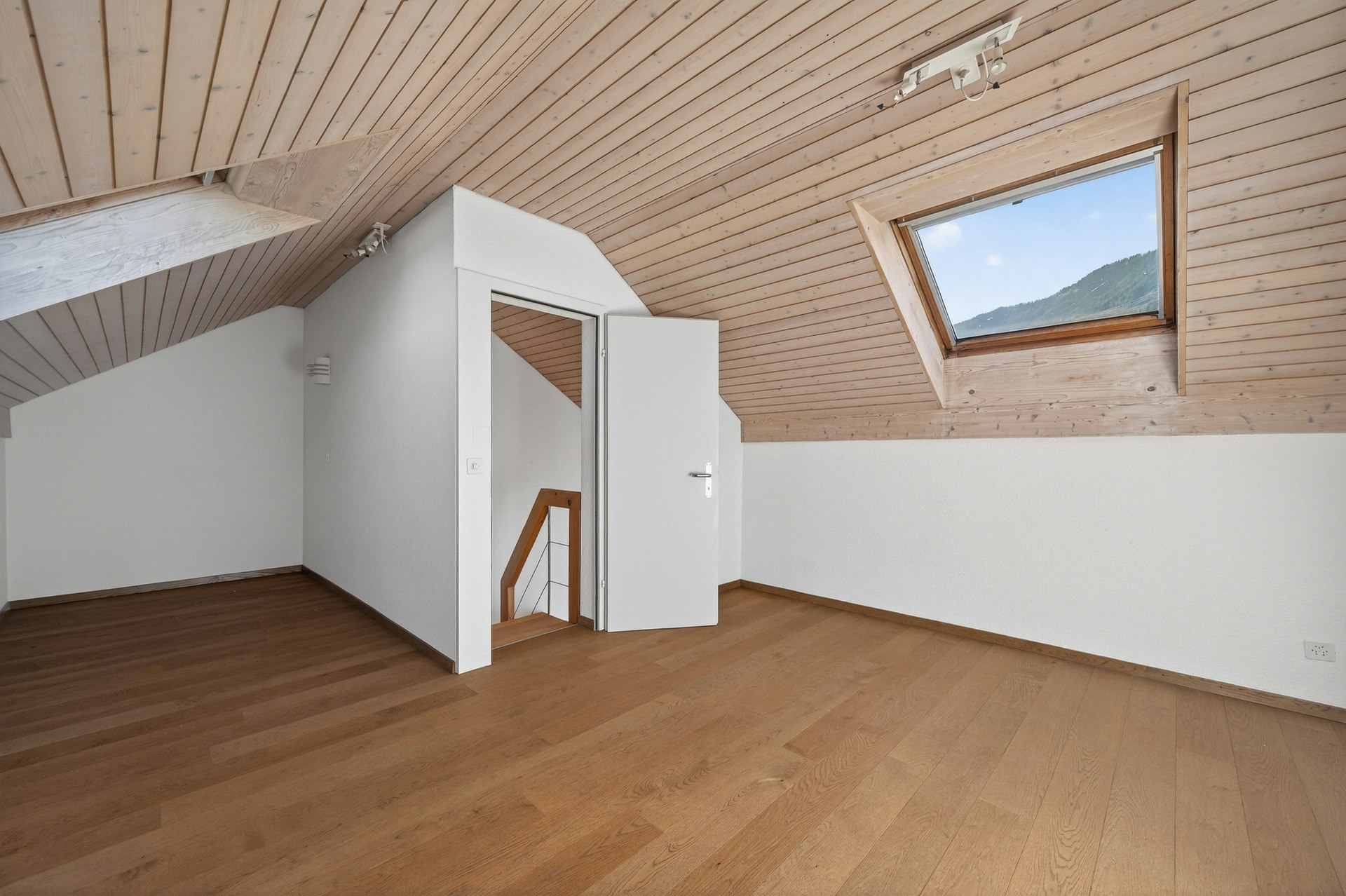 Dachgeschossraum mit Holzdecke und Dachfenster