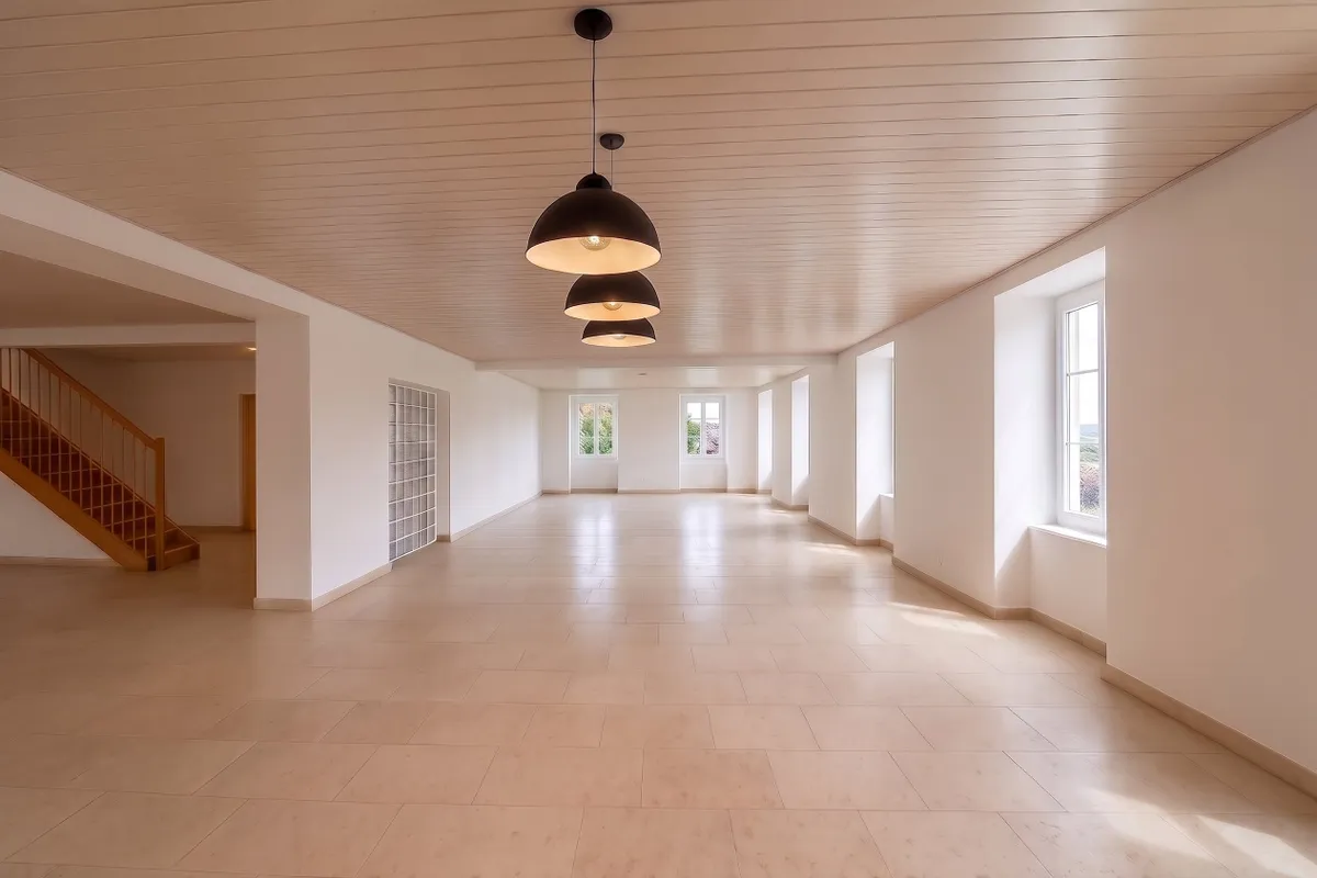 Großer leerer Innenraum mit Fensterreihe und Treppe