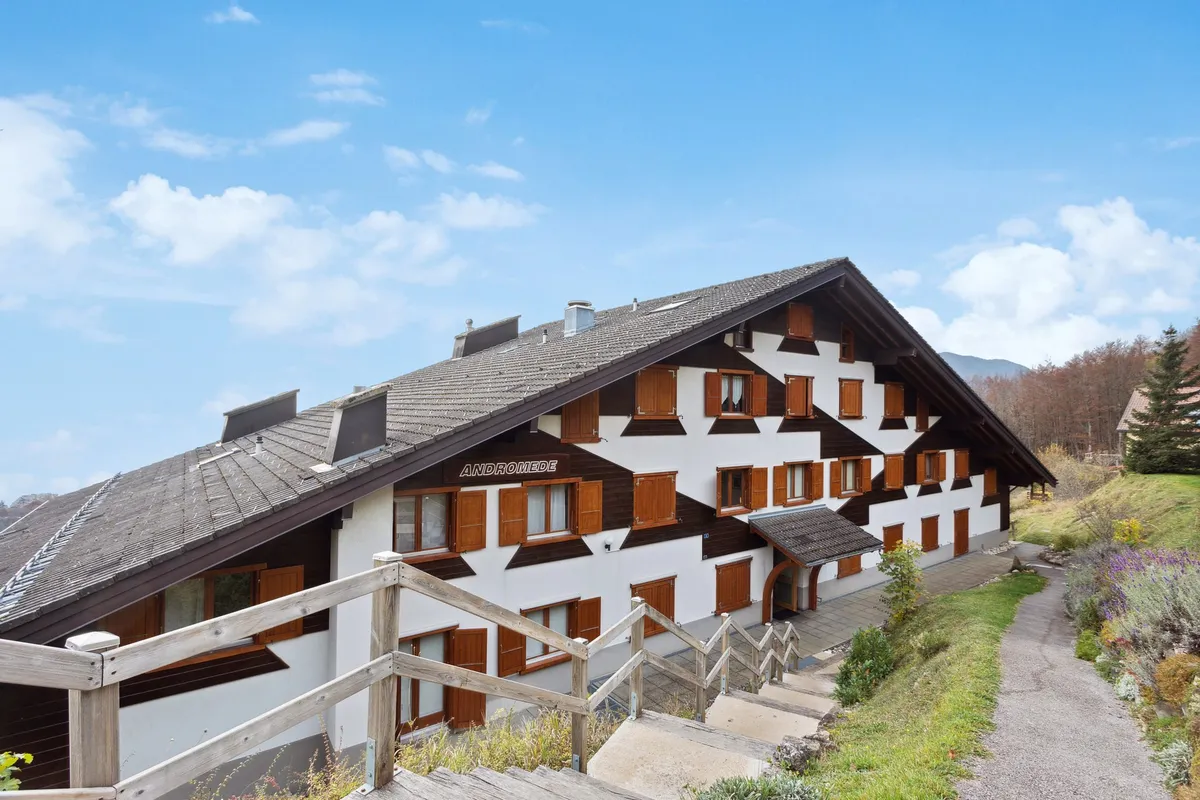 Alpenhaus mit Schrägdach und Holzläden