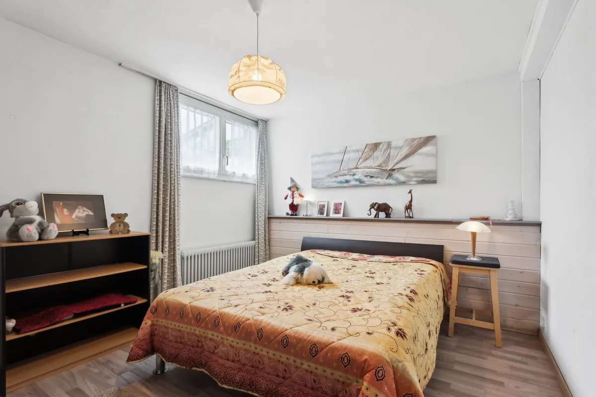 Helles Schlafzimmer mit Doppelbett und Fenster