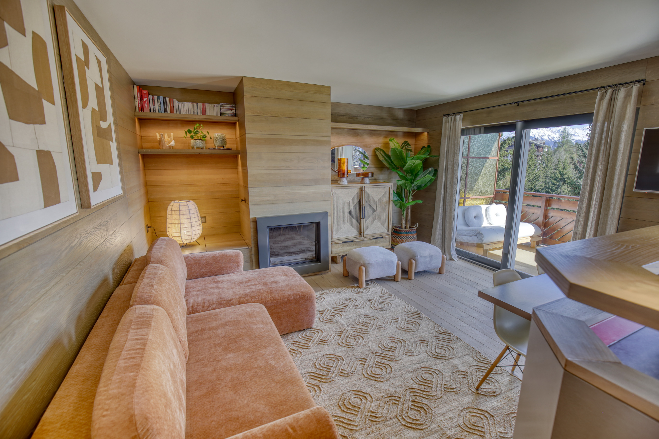 Gemütliches, modern eingerichtetes Wohnzimmer mit Holzverkleidung und Balkonblick