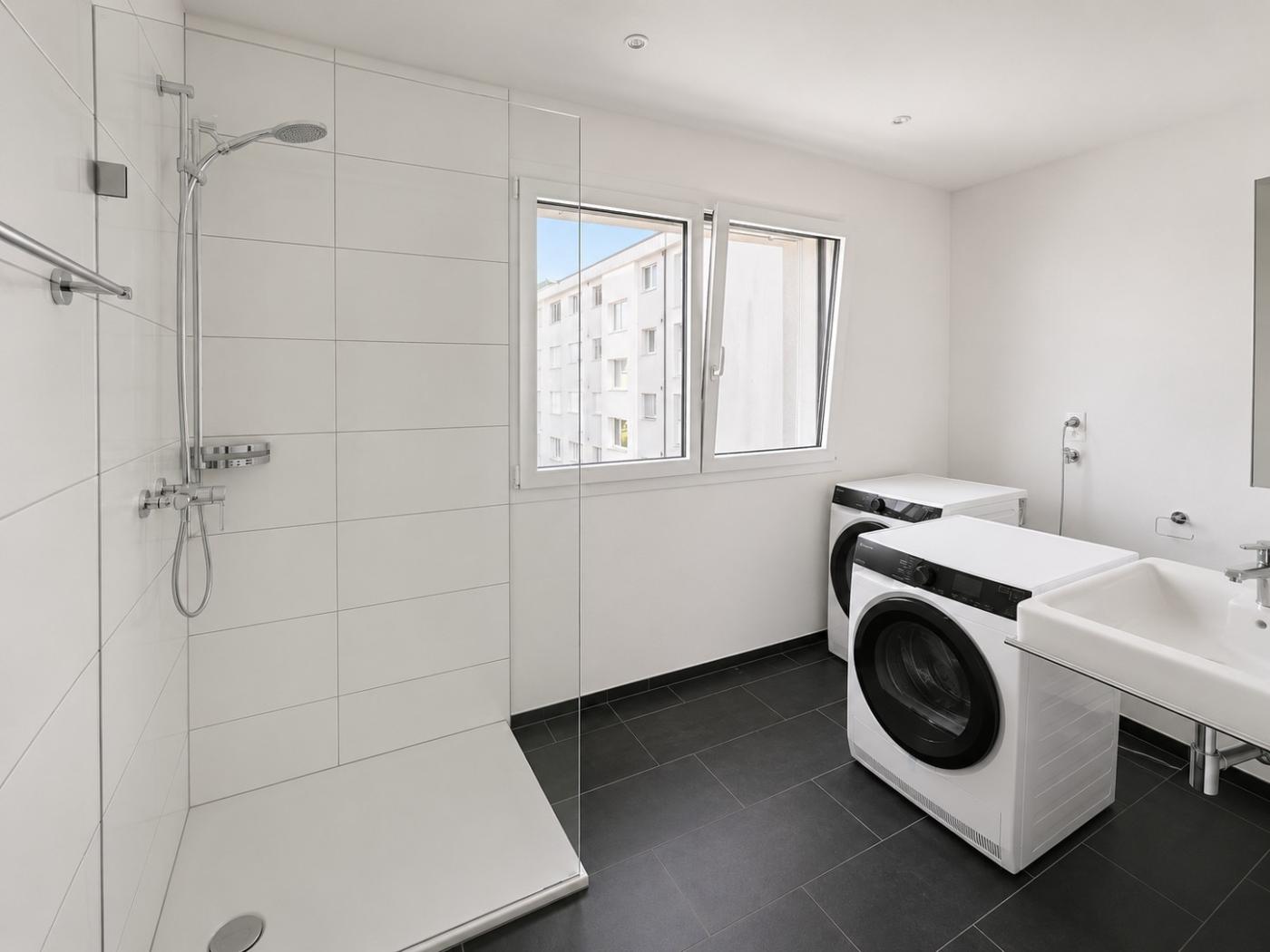 Moderner Hauswirtschaftsraum mit Dusche und Waschmaschinen