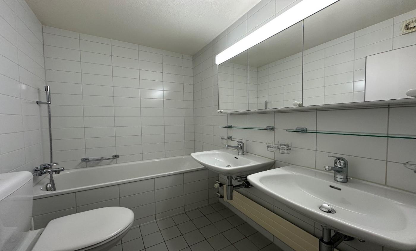 Helles Badezimmer mit Wanne, Doppelwaschtisch und Spiegelschrank