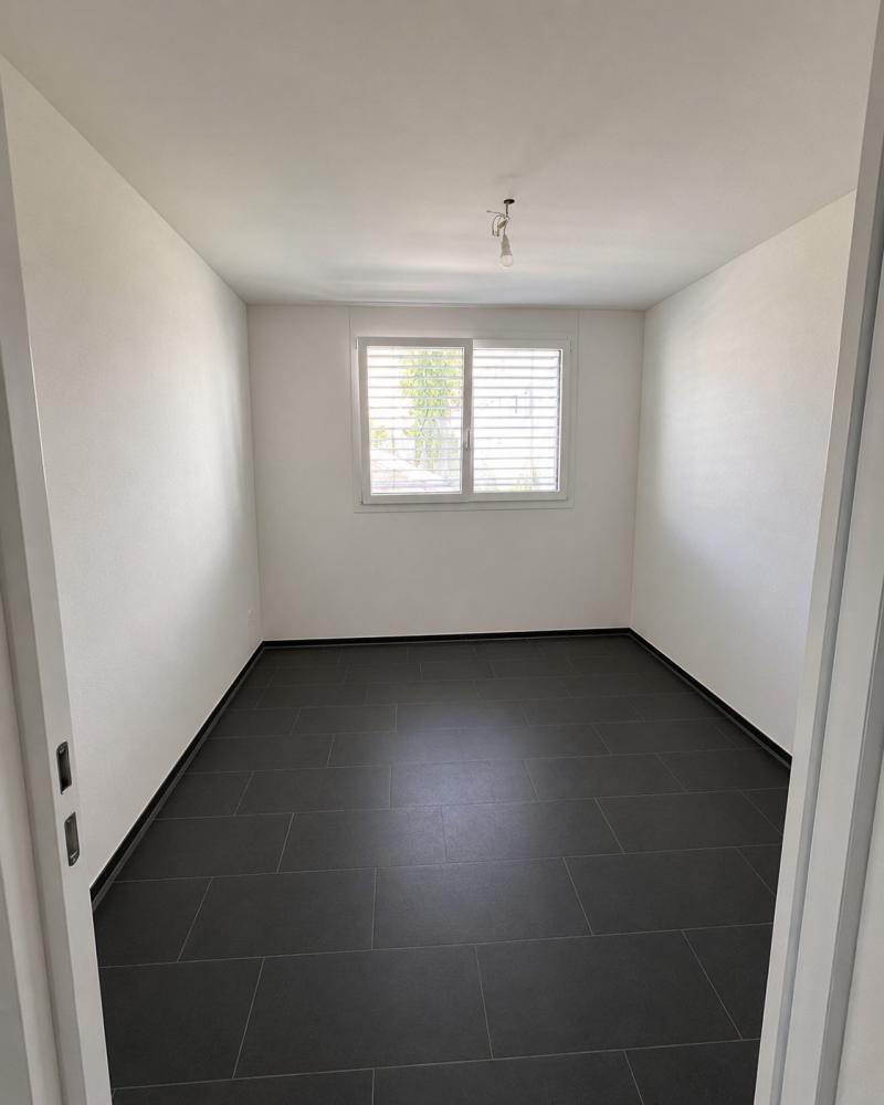 Leerer, schmaler Raum mit Fliesenboden und Fenster