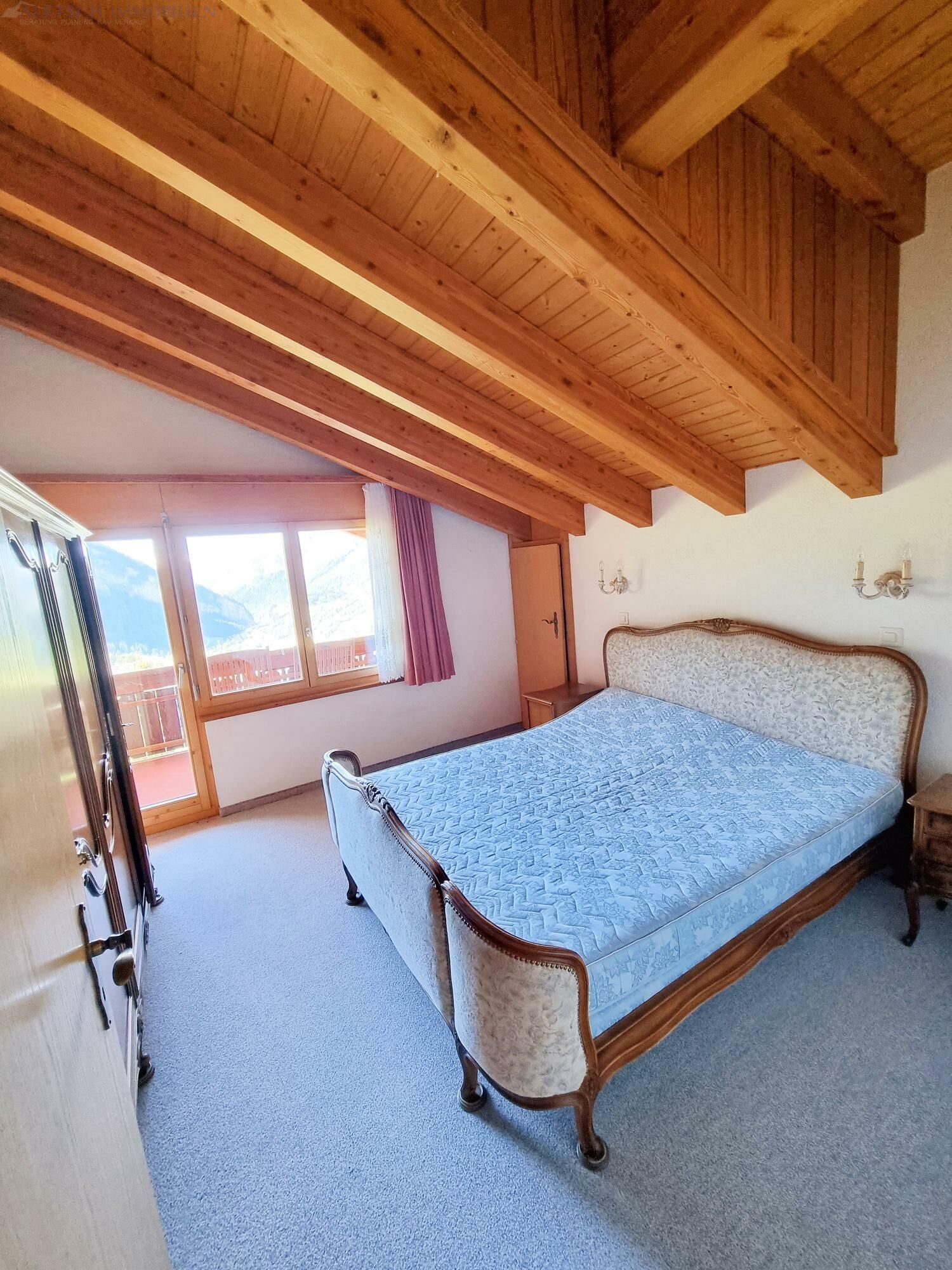 Schlafzimmer mit Holzdecke und Bergblick