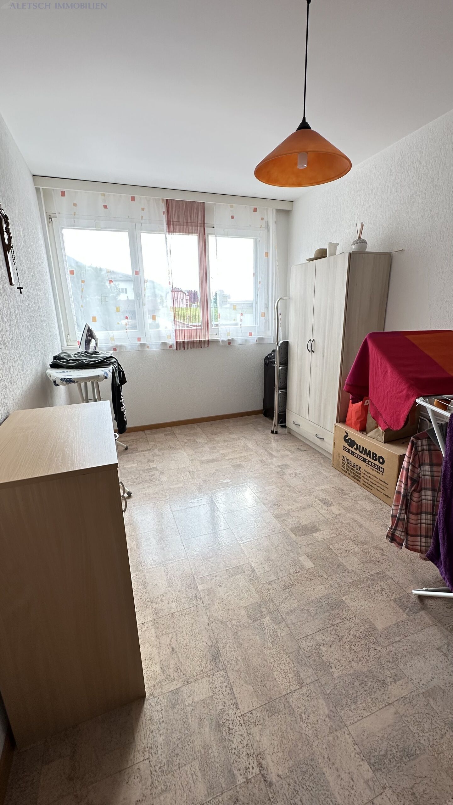 Helles, schmal geschnittenes Zimmer mit Fensterfront