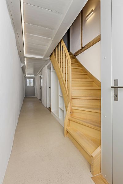Heller Flur mit Holztreppe