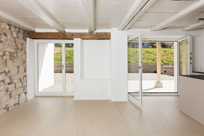 Heller Wohnraum mit Natursteinwand und Terrassentüren