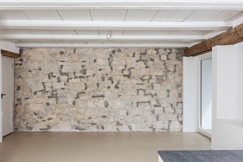 Leerer Raum mit Natursteinwand und Holzbalken