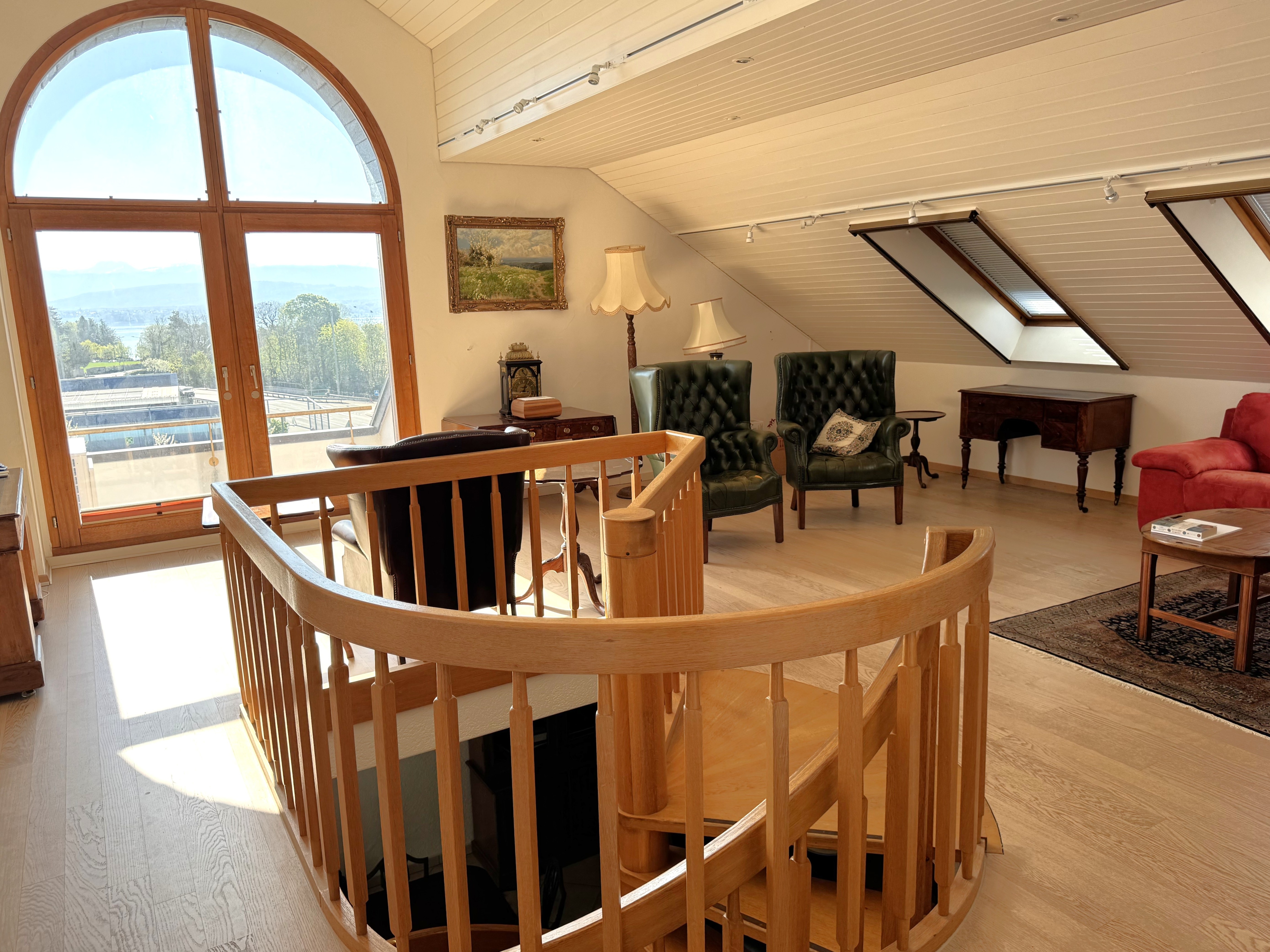 Heller Dachgeschoss-Wohnraum mit Galerietreppe und Ausblick