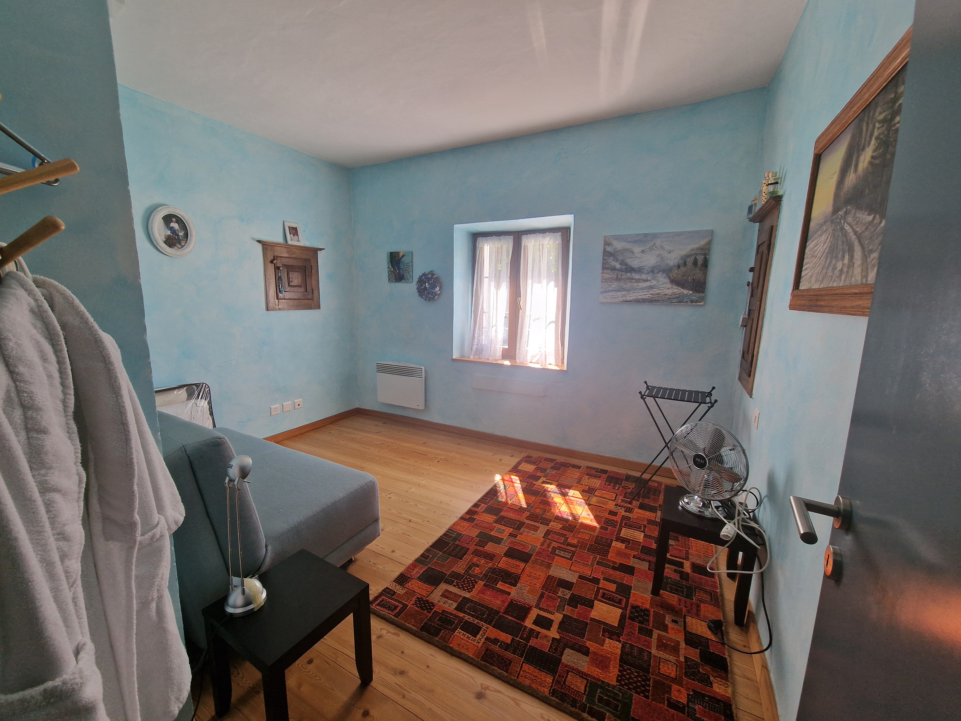 Kleiner Raum mit blau gestrichenen Wänden und Holzfußboden
