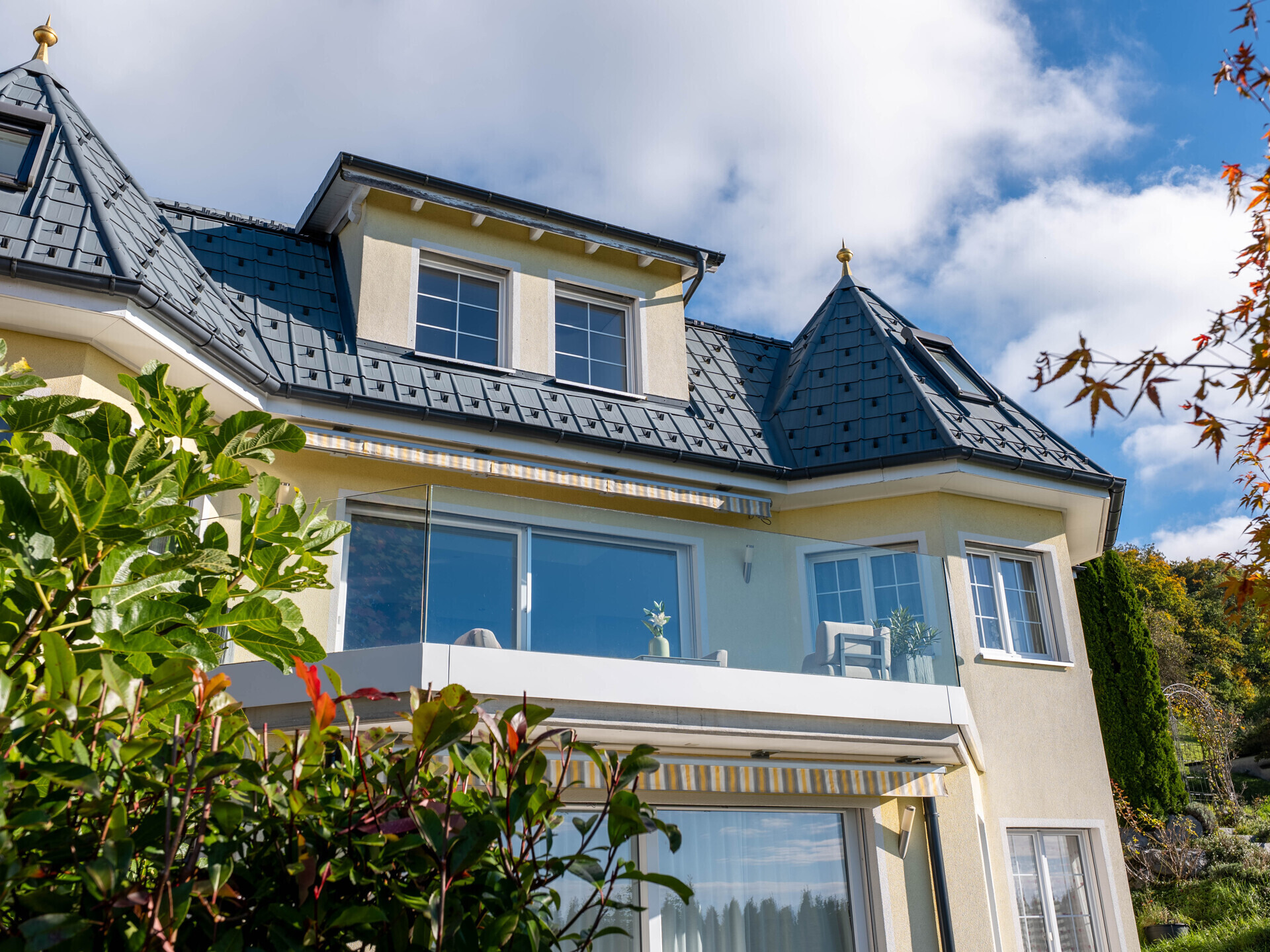 Außenansicht einer Villa mit Turmdach und Balkon