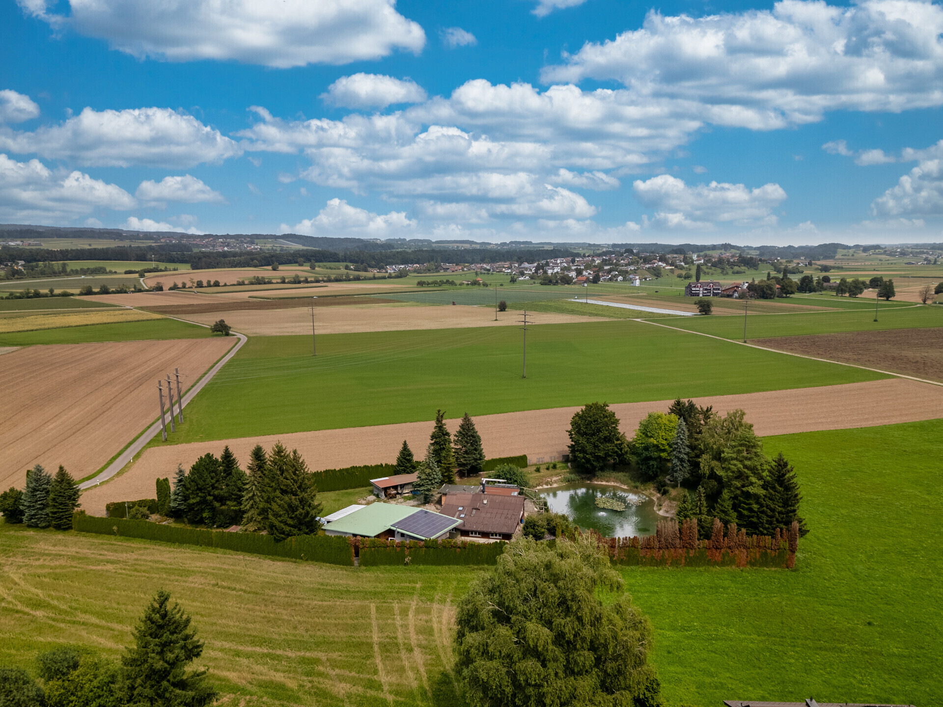 Luftaufnahme eines ländlichen Anwesens mit Teich